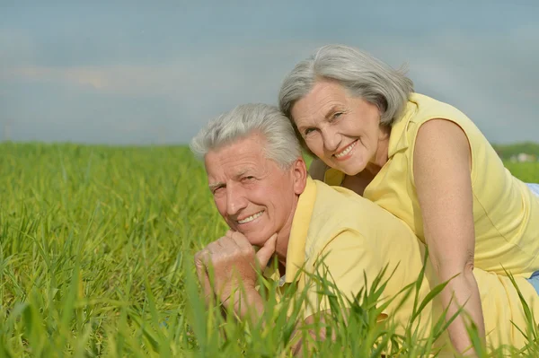 Old couple lying on the field — Stock Photo, Image