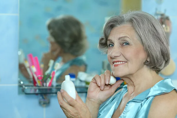 Mujer haciendo maquillaje en el baño — Foto de Stock