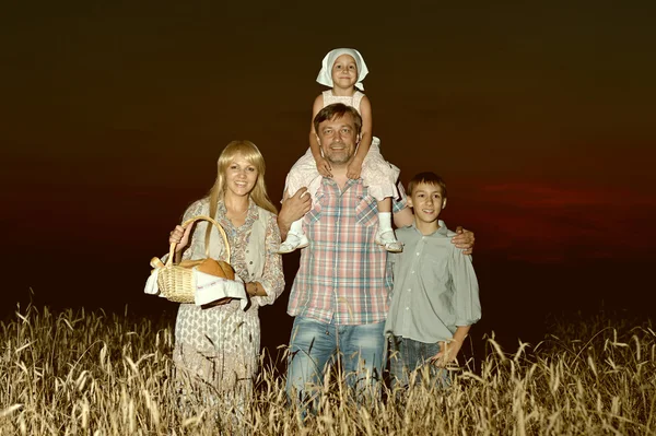 Família feliz no campo de trigo — Fotografia de Stock