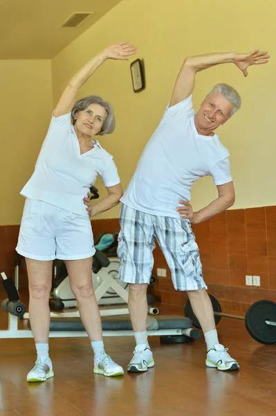Couple d'âge mûr étirant dans la salle de gym — Photo