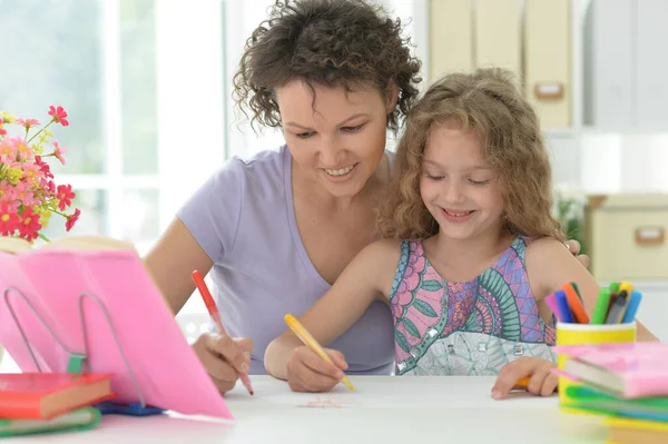 Liten Söt Flicka Gör Hemma Arbete Med Mamma Vid Bordet — Stockfoto