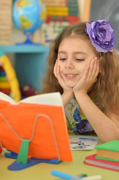 Μικρό Χαριτωμένο Κορίτσι Διαβάζει Βιβλίο Στο Τραπέζι Στο Σπίτι — Φωτογραφία Αρχείου