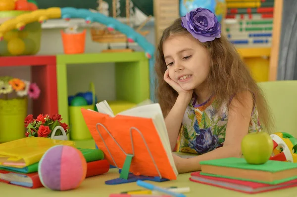 Μικρό Χαριτωμένο Κορίτσι Διαβάζει Βιβλίο Στο Τραπέζι Στο Σπίτι — Φωτογραφία Αρχείου