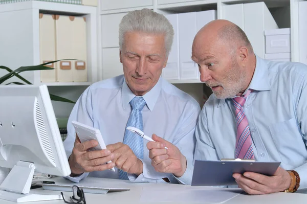 Zwei Geschäftsleute Sitzen Schreibtisch Und Arbeiten Mit Taschenrechner — Stockfoto