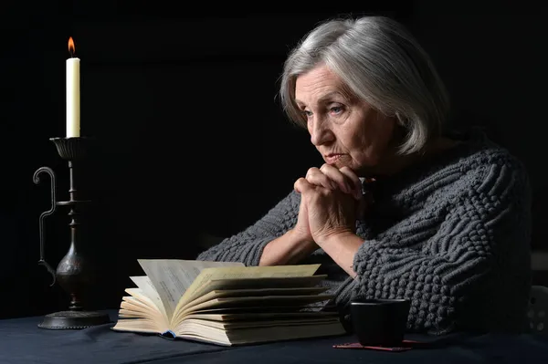 Starší Žena Knihou Doma Tmavém Pozadí — Stock fotografie