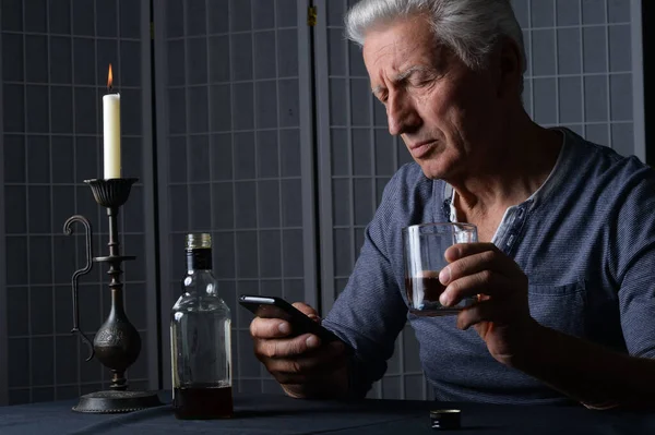 Blanke Senior Man Met Smartphone Fles Alcohol Tafel — Stockfoto