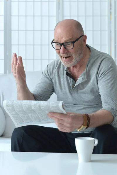 Senior Man Met Kop Koffie Krant Thuis — Stockfoto