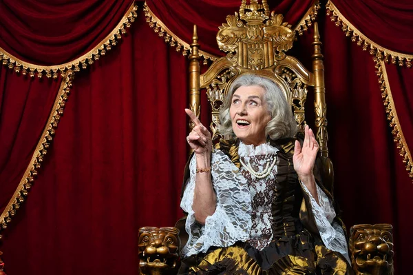 Happy Beautiful Senior Queen Pointing Throne — ストック写真