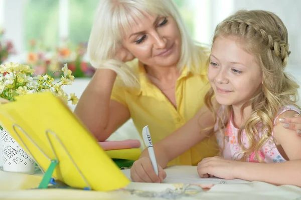 Söt Tjej Gör Hemarbete Med Mamma Vid Bordet Hemma — Stockfoto