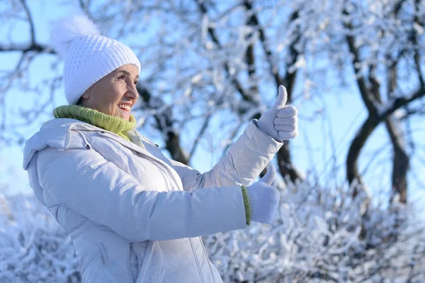 Beautiful Senior Woman Thumbs Snowy Winter Park — Stockfoto