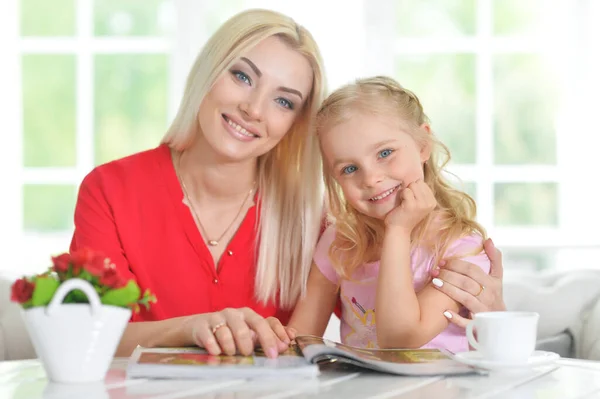 Sonriente Madre Con Hija Pequeña Con Revista Casa —  Fotos de Stock