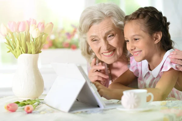 Schattig Klein Meisje Met Haar Oma Zoek Naar Tablet — Stockfoto