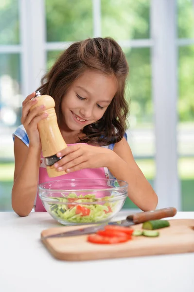 可爱的快乐女孩在厨房里煎沙拉 — 图库照片