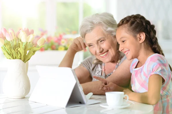 Schattig Klein Meisje Met Haar Oma Zoek Naar Tablet — Stockfoto