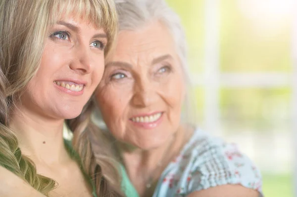 Mature Woman Embracing Adult Daughter Home — Stock Photo, Image