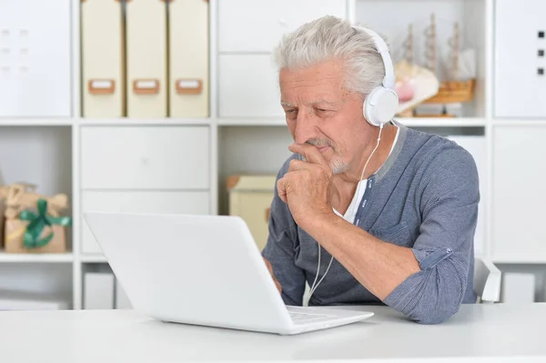 Przemyślany Starszy Mężczyzna Słuchawkach Laptopem Domu — Zdjęcie stockowe