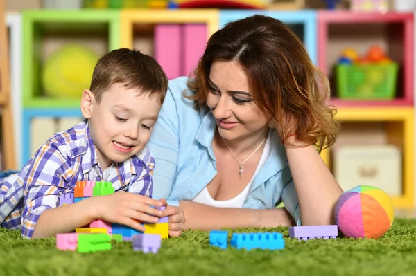 女人和儿子在地板上玩彩色塑料块 — 图库照片