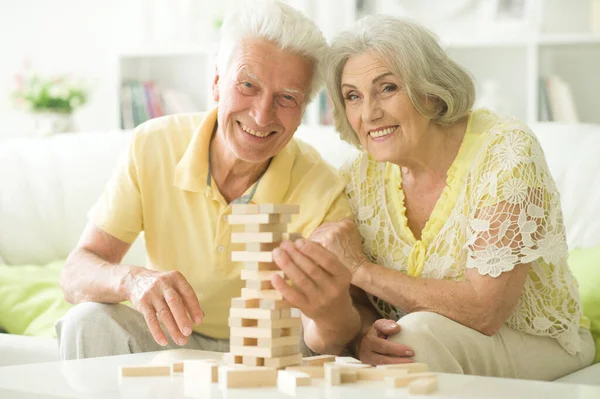 幸せな先輩夫婦は家で木のブロックで遊んでいます — ストック写真