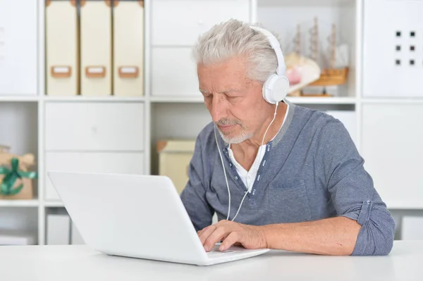 Przemyślany Starszy Mężczyzna Słuchawkach Laptopem Domu — Zdjęcie stockowe