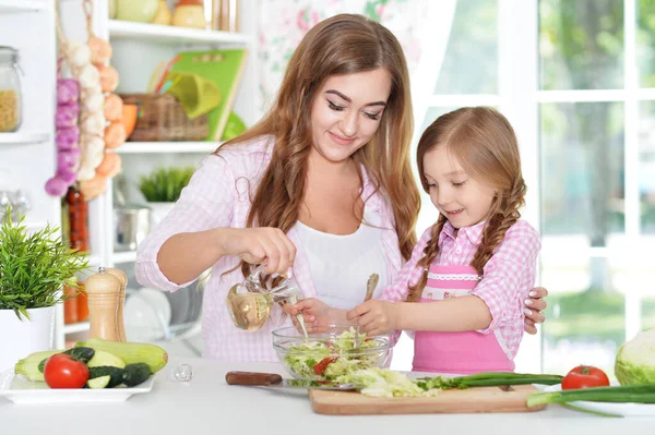 女孩和她妈妈一起在厨房桌上做沙拉 — 图库照片