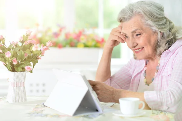 Krásná Starší Žena Pomocí Moderní Tablet Při Pití Čaje — Stock fotografie