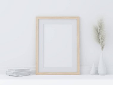 Beyaz oda zeminine asgari biçimdeki ahşap poster çerçevesi vazo ve beyaz kitaptaki saman çiçekleriyle süslenmiş.