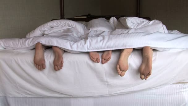 Семейные ноги в постели — стоковое видео