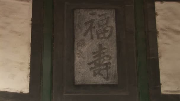 Caracteres chinos tallados en la puerta — Vídeo de stock