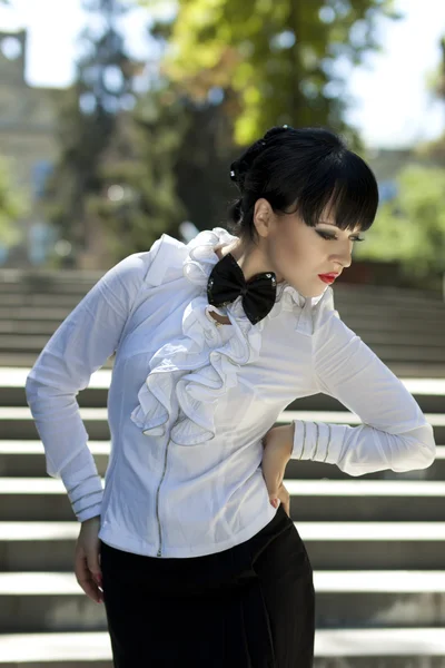 De koket brunette in een witte blouse — Stockfoto