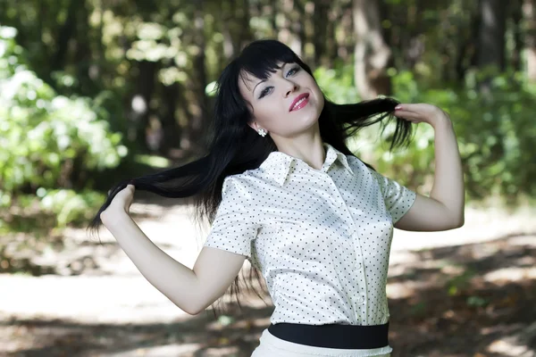 Charming young brunette in park — Stock Photo, Image