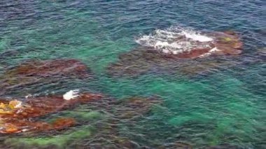 Sea waves slide through stones in the sea