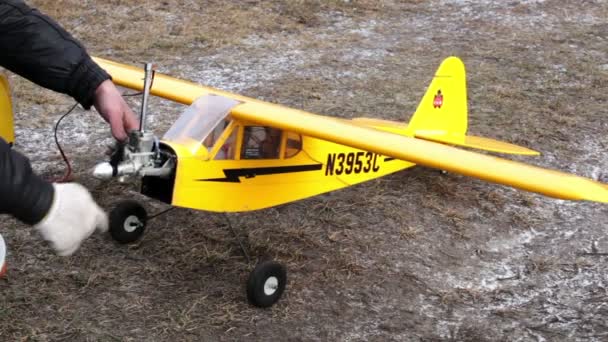 Hände drehen Propeller eines gelben Modellflugzeugs — Stockvideo