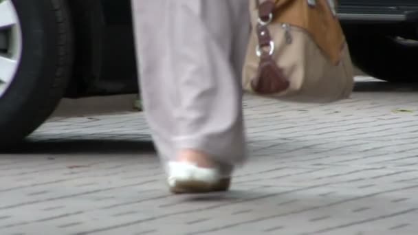 The woman in trousers goes down the street. Blurred scene — Stock Video