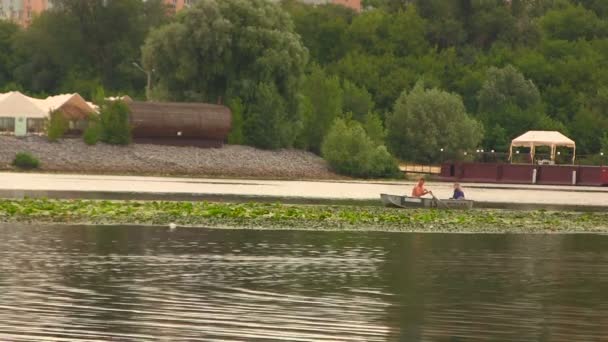 男は、川を下るボートで女の子をロールします。 — ストック動画