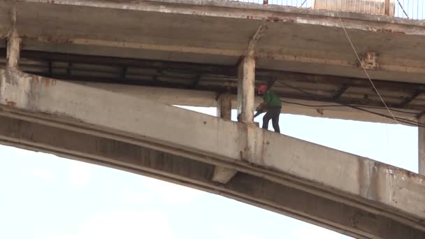 Silhouette of the worker on a bridge span. Sound. — Stock Video