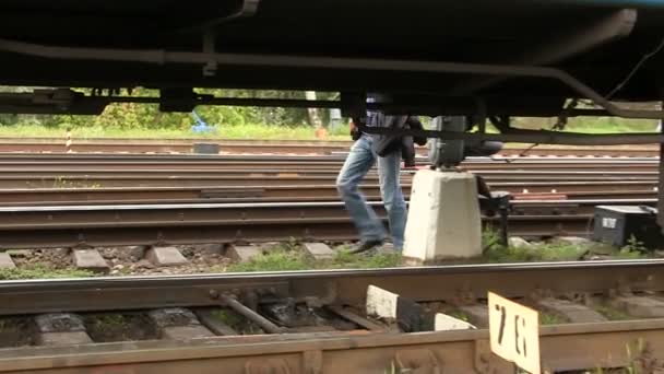 Füße der Person, die sich hinter einem Eisenbahnwagen befindet — Stockvideo