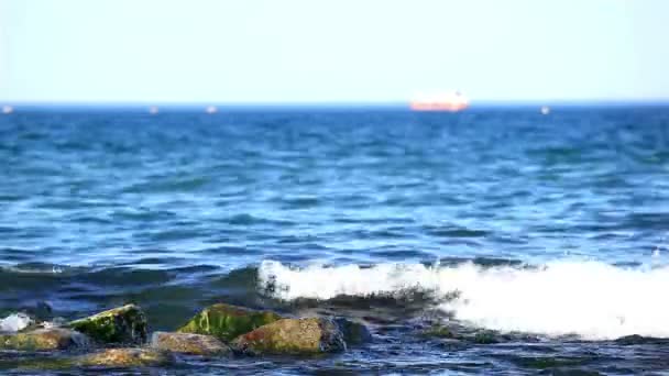 Waves fight about stones to the sea and a ship silhouette — Stock Video