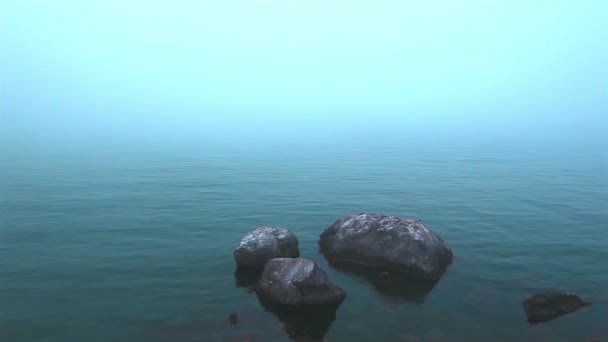 Sea in a fog and stones in foreground. Landscape — Stock Video