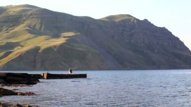 bir iskelede yalnız balıkçı