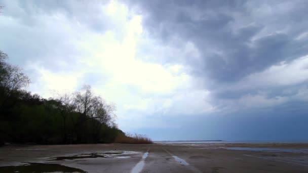La costa del río durante una lluvia con una pista desde el coche — Vídeos de Stock