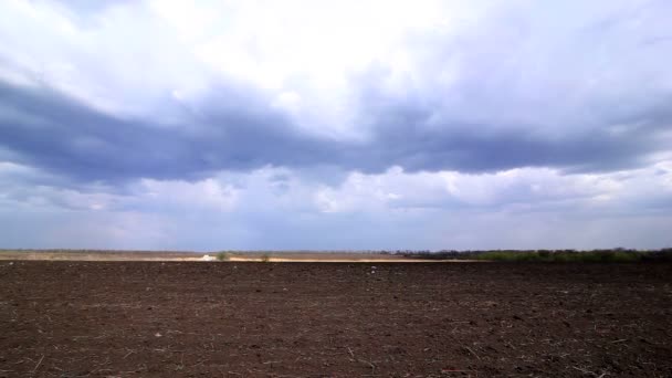 Wolkenbewegung über einem brachliegenden Feld. Zeitraffer — Stockvideo
