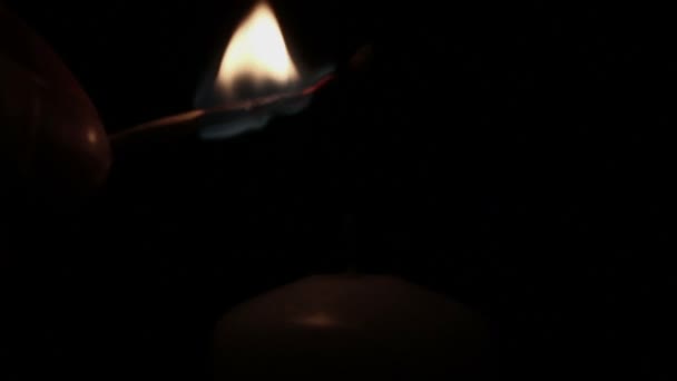 Man's hand lights a candle in dark — Stock Video