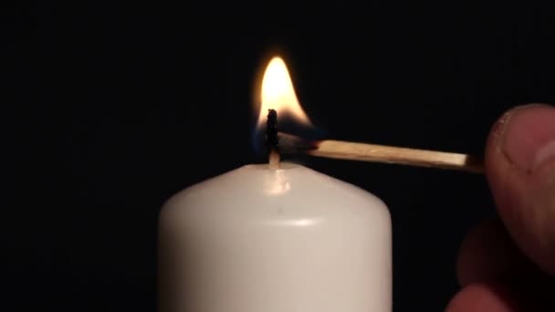 Man's fingers with a match light candle — Stock Video