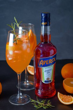 İtalyan tentürü Aperol, Aperol Spitz kokteyli yapmak için. Şişede kırmızı-turuncu şarap. Alkolik içki. Portakallı ve otlu aperatif. Yemek hala hayattadır. Ukrayna, Kyiv - 26 Ağustos 2021.