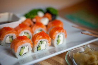 Somon suşi seti. Suşi Philadelphia 'yı kırmızı balıklı, somonlu, kırmızı havyarlı. Masaj havyarının altında yumuşak avokado ve krem peynirle yuvarlan. Klasik suşi. Gıda arkaplanı.