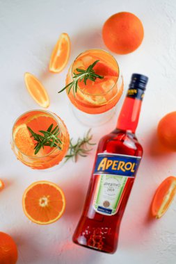 İtalyan tentürü Aperol, Aperol Spitz kokteyli yapmak için. Şişede kırmızı-turuncu şarap. Alkolik içki. Portakallı ve otlu aperatif. Yiyecekler beyazda hala hayat. Ukrayna, Kyiv - 26 Ağustos 2021