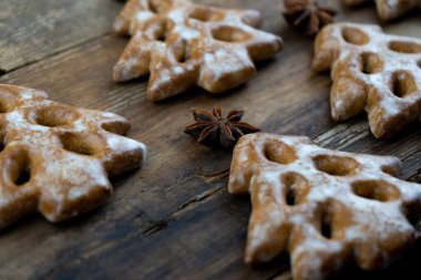 Noel ağacı şeklinde Noel kurabiyeleri. Yeni yıl yemeği. Anason yıldızı. Şenlikli pişmiş yiyecekler. Masada zencefilli çörek var. Desen