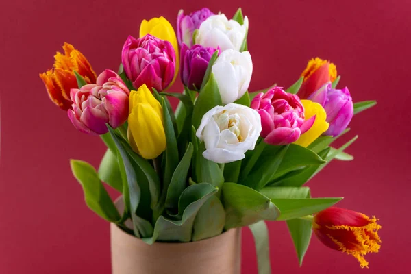 Mix of spring tulips flowers. Bouquet in a vase. Multi-colored spring flower. Gift. Red, pink, white and yellow. Background with flowers tulips close-up different colors