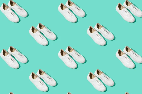 ミントブルーの背景にホワイトのスニーカーパターン 靴は快適でカジュアルなものです 靴屋の背景 新しい靴のペア — ストック写真