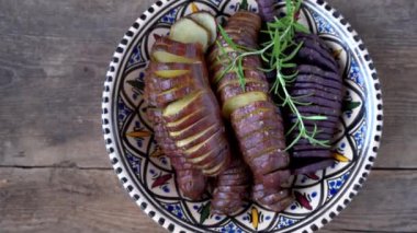 Tatlı patates, tavada pişirilmiş tatlı patatesler. Kızartılmış ve baharat ve tuzla pişirilmiş. Parçalara ayırıp dilimlere ayırmak. Sağlıklı yiyecekler üst görüntüde. Tahta bir masada patates yemeği.
